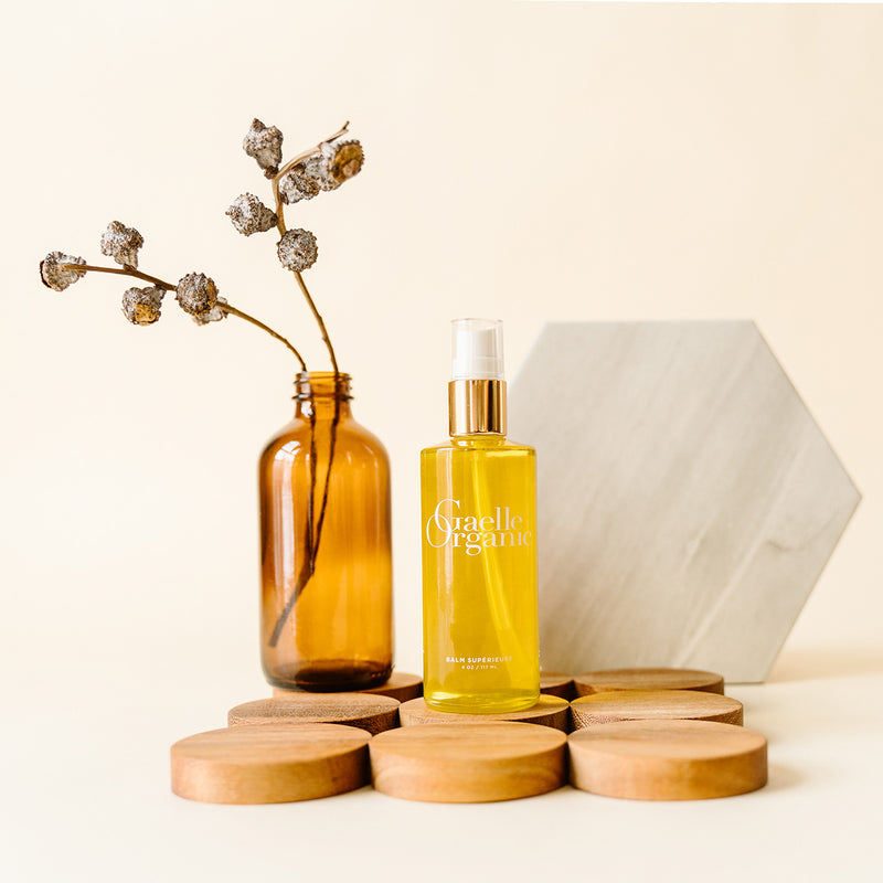 Natural Makeup Remover Standing On Round Wooden Disks With Dried Flowers In Bottle