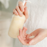 Hands Holding and Dispensing Body Moisturizer