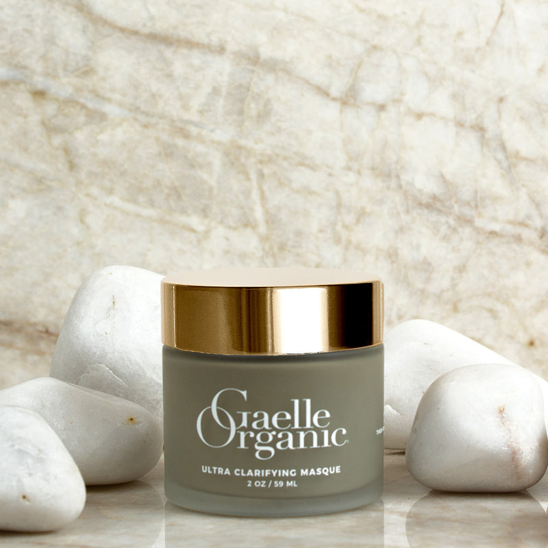 An organic clarifying mask on a marble shelf with white stones