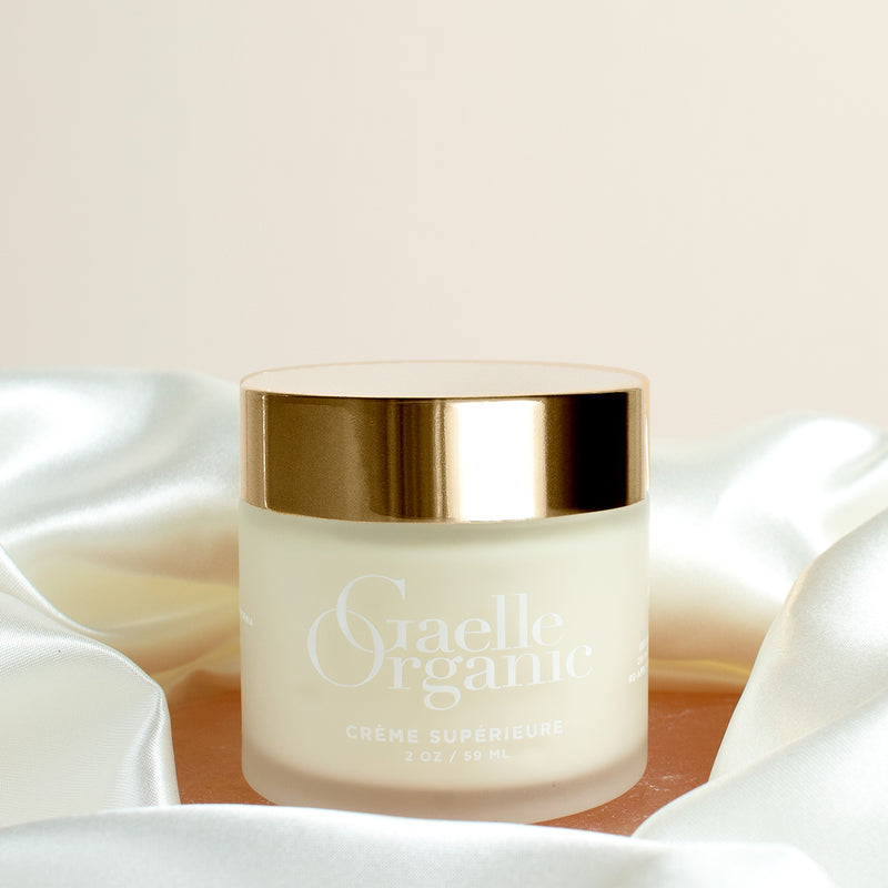 Creme Superieure, the best organic moisturizer for dry skin, on a pink stone with silk scarf
