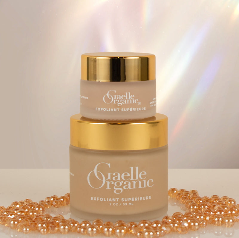 Exfoliant Superieure, the best exfoliator for fine lines, in full and travel sizes with gold beads and a prism background