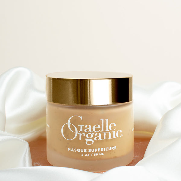 Masque Superieure, an organic hydrating mask, on a pink stone with a silk scarf
