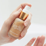 Hand holding Serum Superieure, an anti-aging serum to brighten dry skin