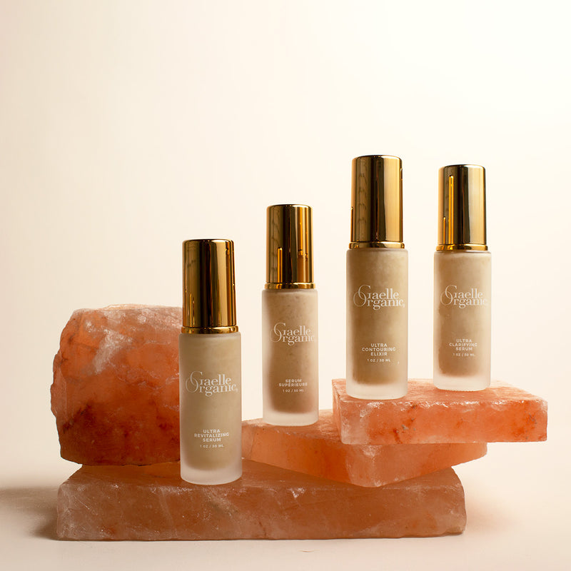 The best serums for aging skin, on pink quartz slabs against a white background.