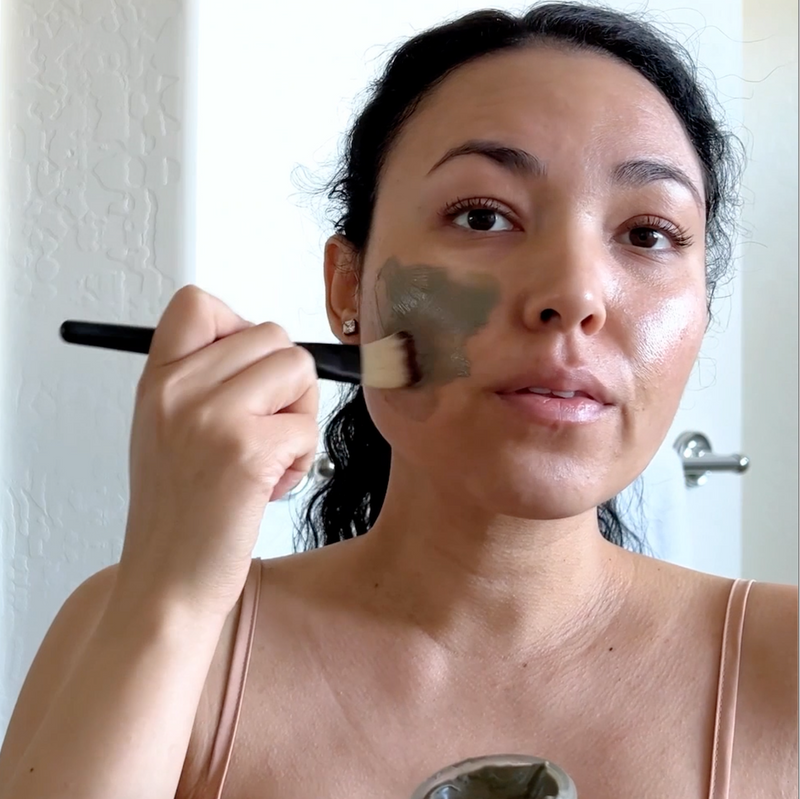 Model brushing Ultra Clarifying Masque on her face to reduce redness and breakouts