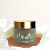 Ultra Clarifying Masque, an organic mask to calm breakouts and reduce redness, on a pink stone with a silk scarf