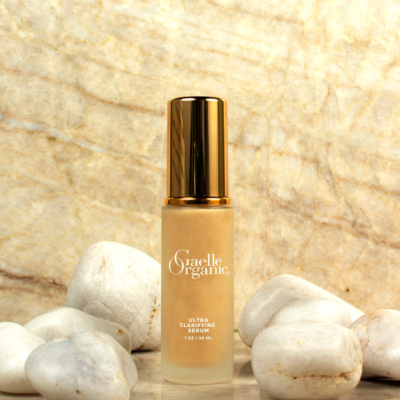 Ultra Clarifying Serum, an organic serum to soothe skin and reduce redness, with white rocks and a marble background
