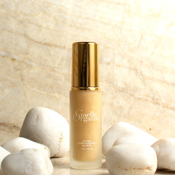 Ultra Contouring Elixir, the best organic serum for firming and contouring jawline and neck, on marble with white stones
